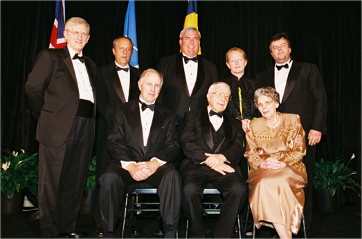 Eight people posing together at a gala