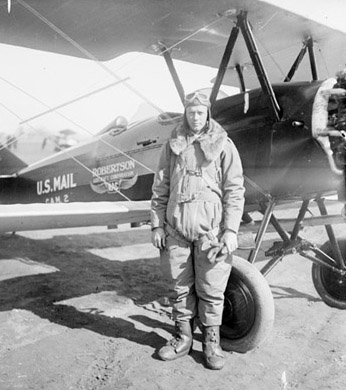 23-year-old Charles Lindbergh standing in front of an airmail plane