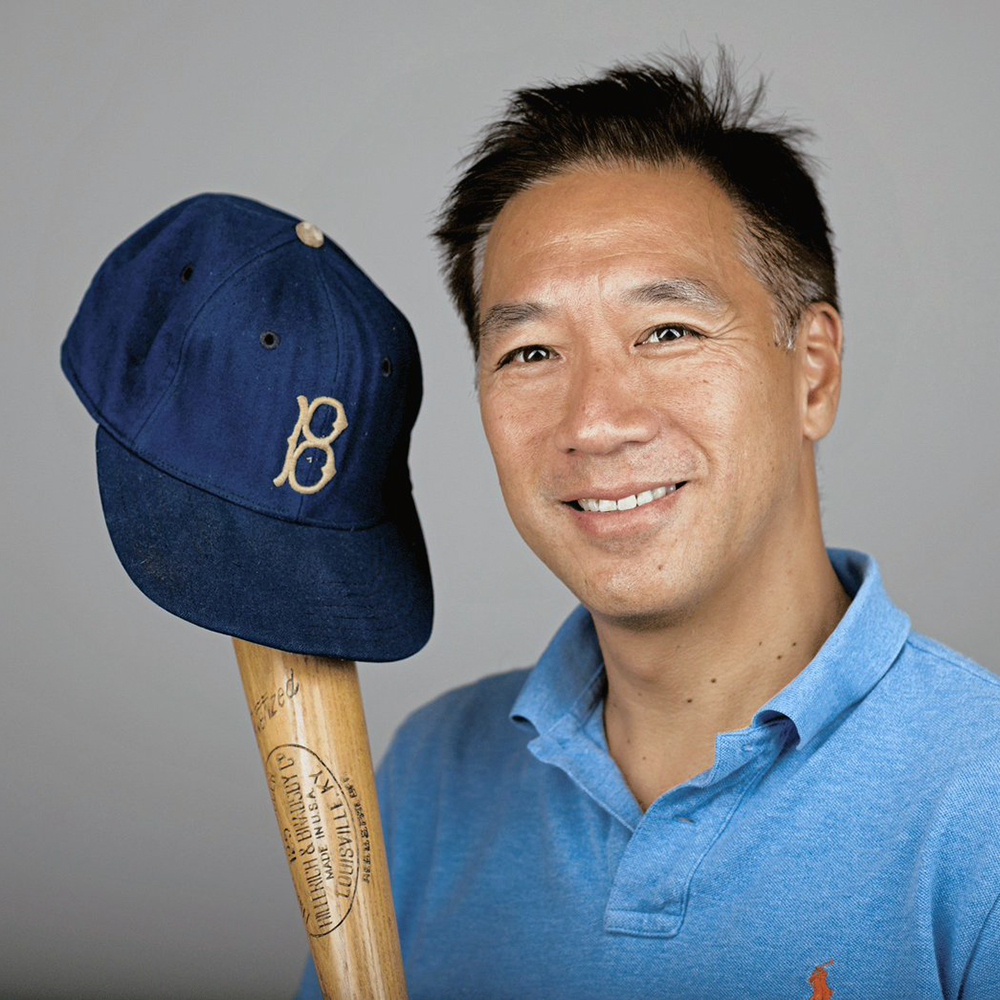 Stephen Wong holding a baseball cap and bat
