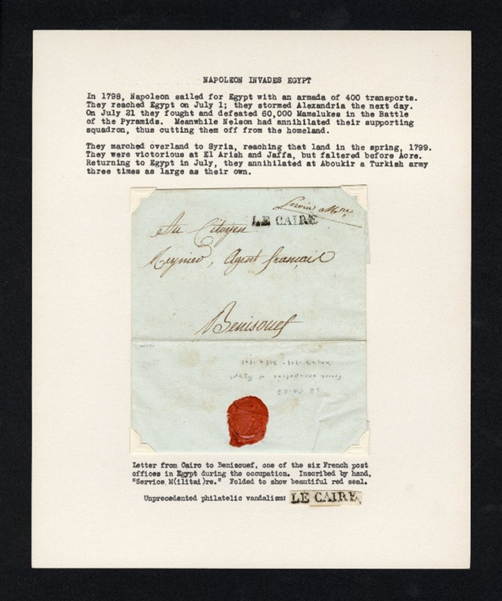 Photograph of page of album with envelope with red wax seal adhered to page; above, typed text describing the envelope