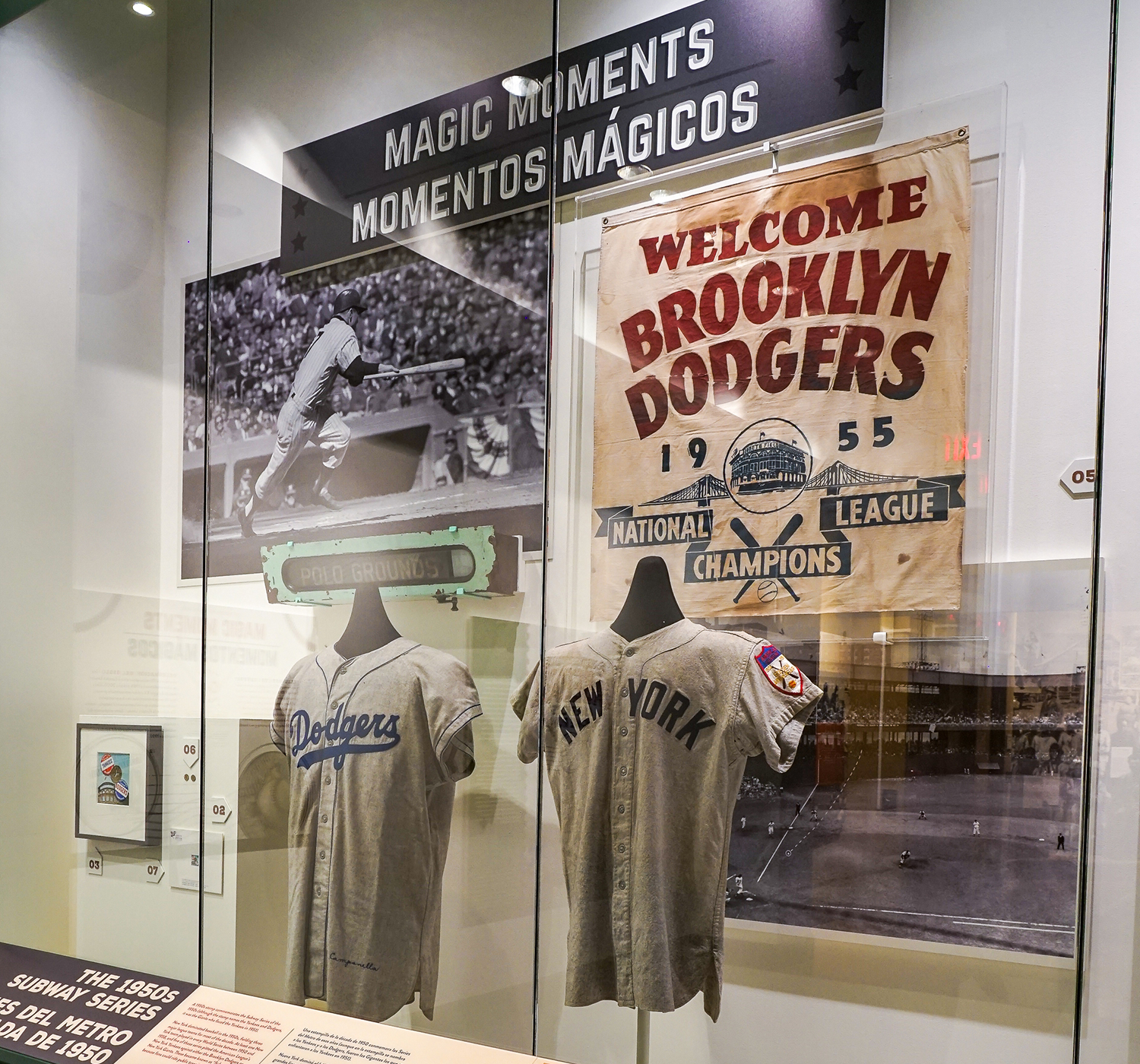 Polo Grounds subway train sign, 1940s; Brooklyn Dodgers National League Champions canvas banner, 1955; Roy Campanella Brooklyn Dodgers road jersey, 1955; and the Yogi Berra New York Yankees road jersey, 1951