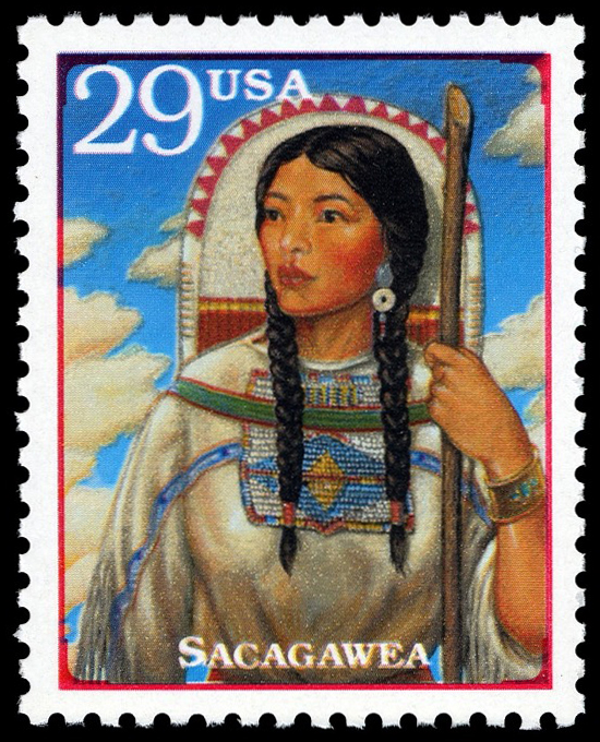 a 29-cent stamp with a picture of an indigenous woman facing the viewer from the waist up, against the backdrop of the sky. Her hair is in two braids and she is wearing embroidered dress; in her left hand she holds a walking stick.