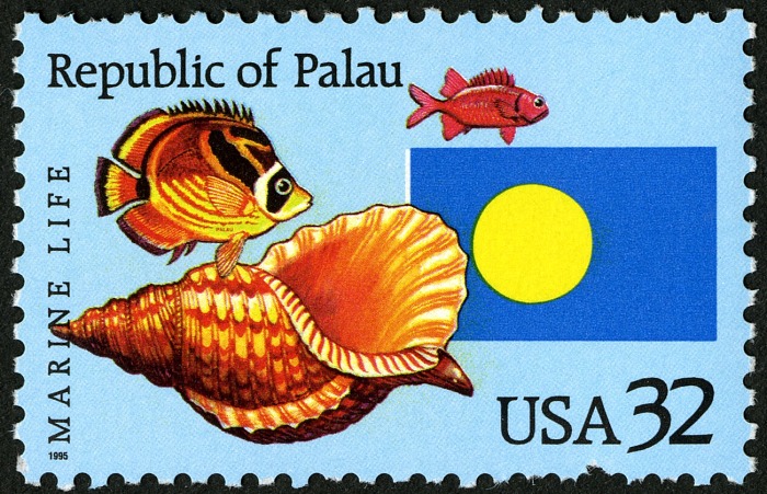 Republic of Palau stamp featuring a seashell, two fish, and the Palau flag