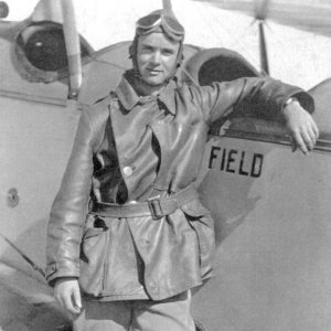 Stanhope S. Boggs wearing pilot gear posing for a photo with an airplane