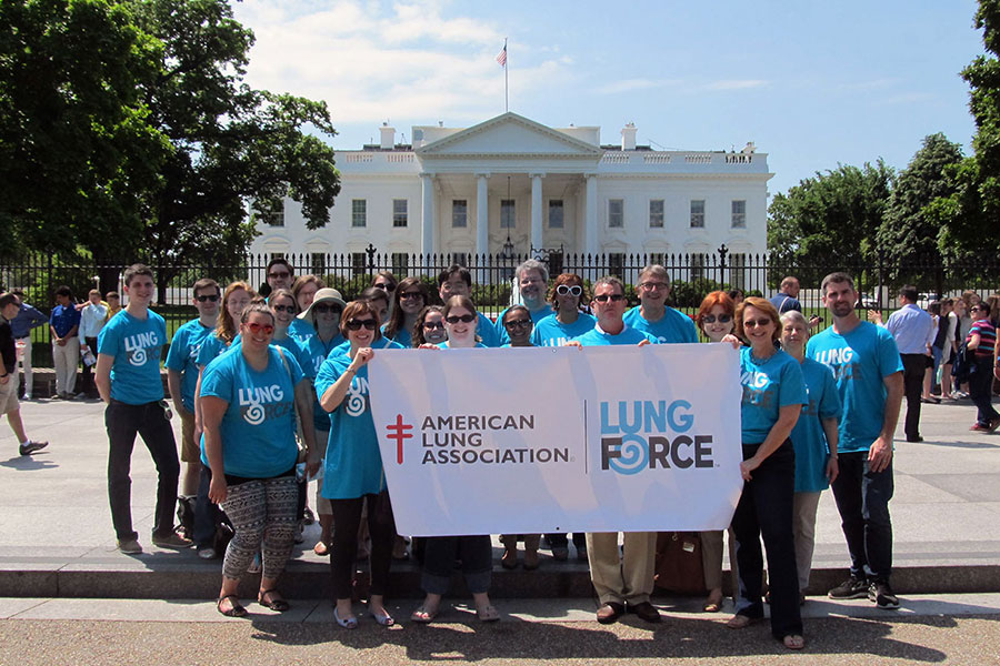 LUNG FORCE standing in front of the White House with Lung Force sign.