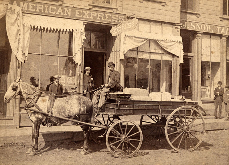 Horse and wagon with driver in front of an American Express office