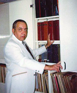 Roberto Pichs standing next to a collection of stamp albums
